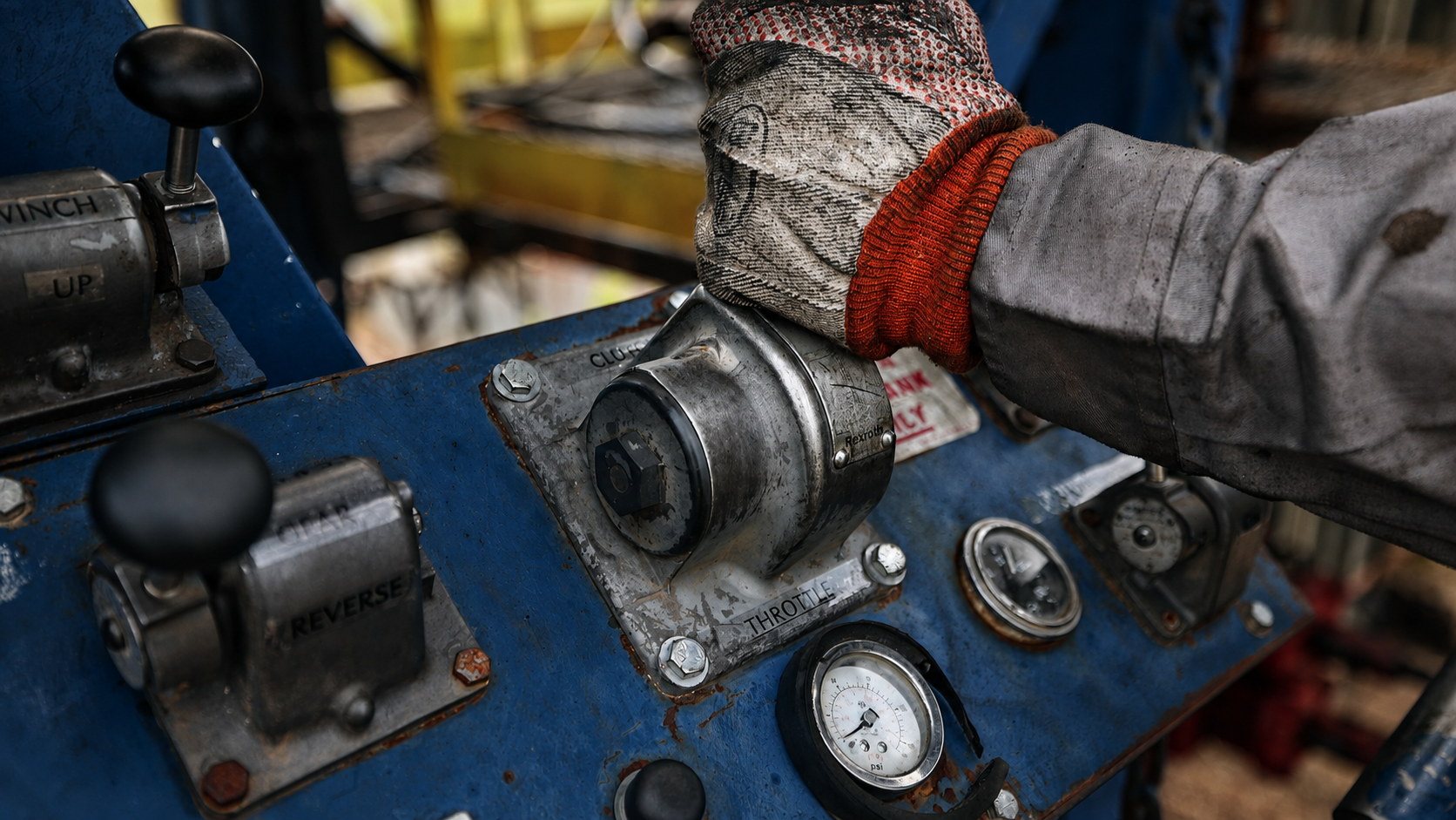 Gloved hand of a Rise Drilling crew member on the rig throttle controls